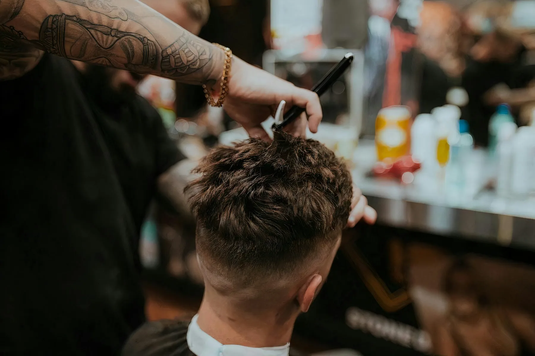 A barber cutting a client's curly hair at Kings Barber